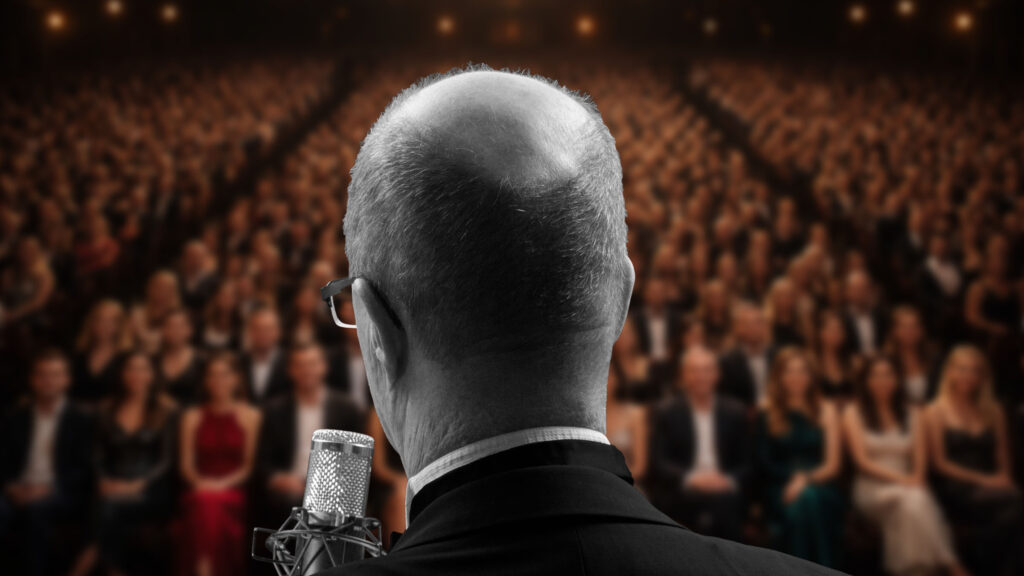 Rückansicht eines Sängers vor ausverkauftem Haus